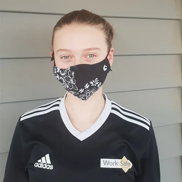A person wearing the black Mexican design face mask