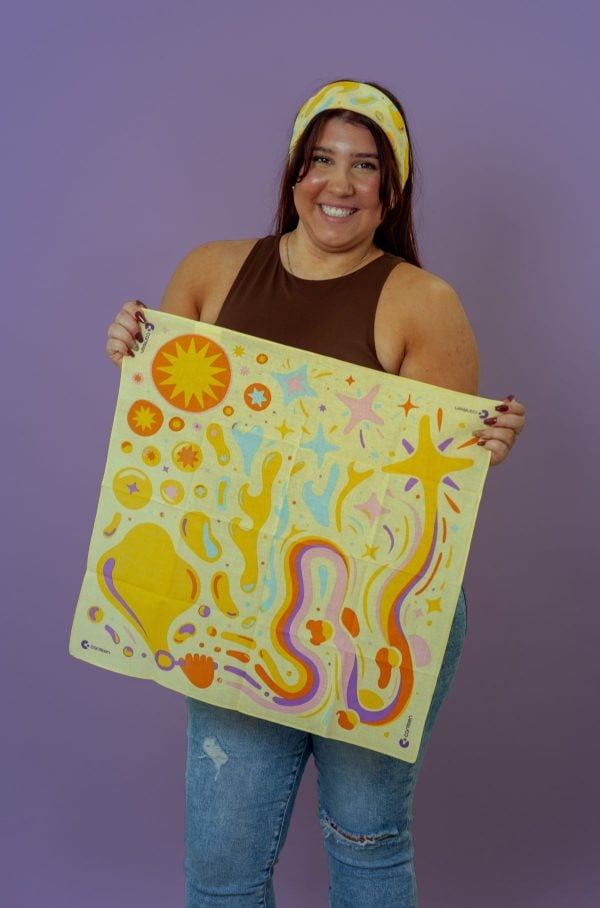 A person wearing and holding the Waves of Courage bandanna
